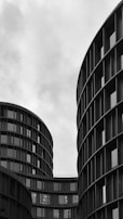 grayscale photo of high rise building with glass window