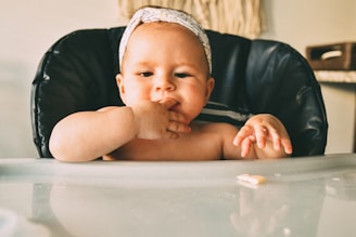 a baby sitting in a high chair eating food