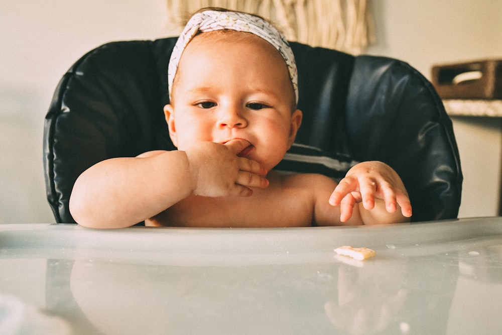 a baby sitting in a high chair eating food