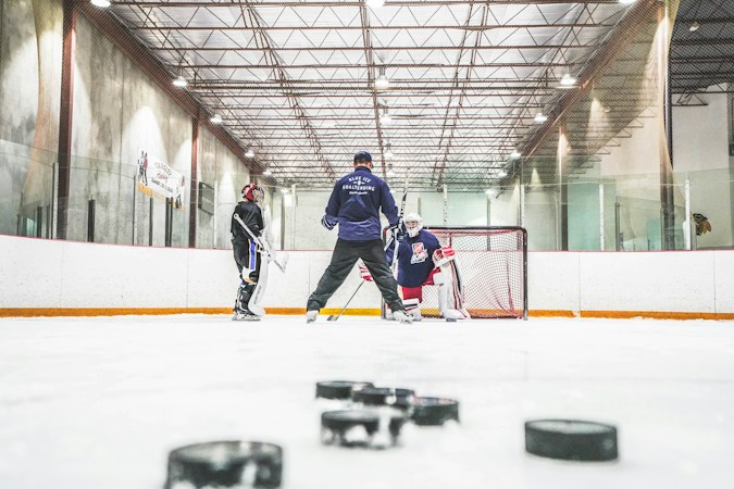 Hockey players skating hard up the ice during a game, representing the Golden Knights roster battles that ended training camp