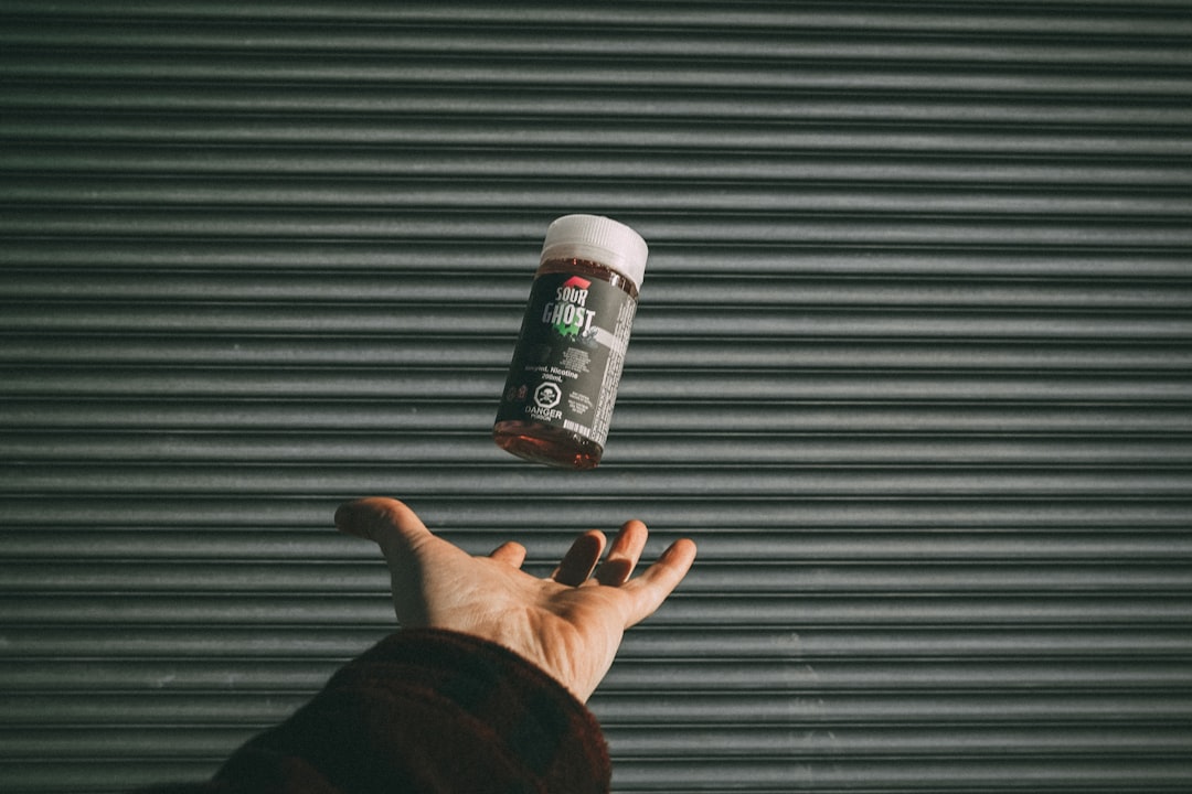 person holding black and white bottle