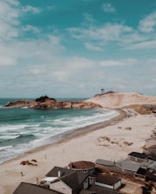 A scenic view of Hardelot beach with a welcoming holiday home nearby.