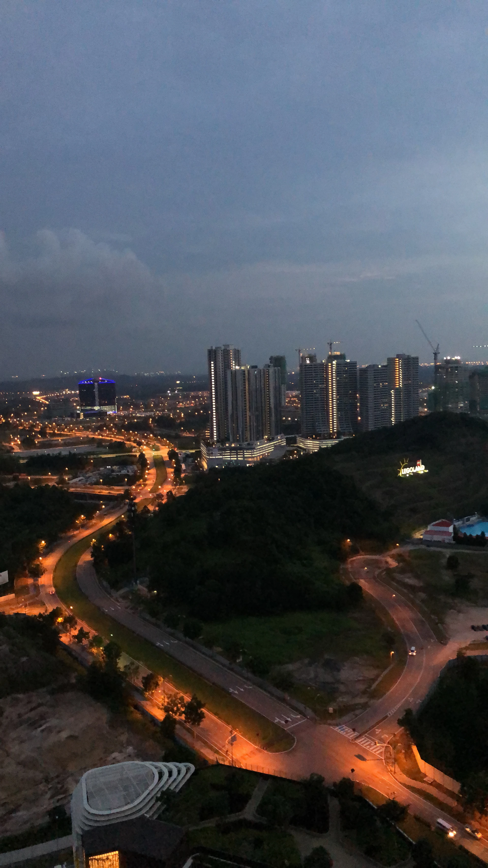 A vibrant cityscape of Naini with well-planned roads and inviting investment properties near the Jhalwa airport area at dusk.