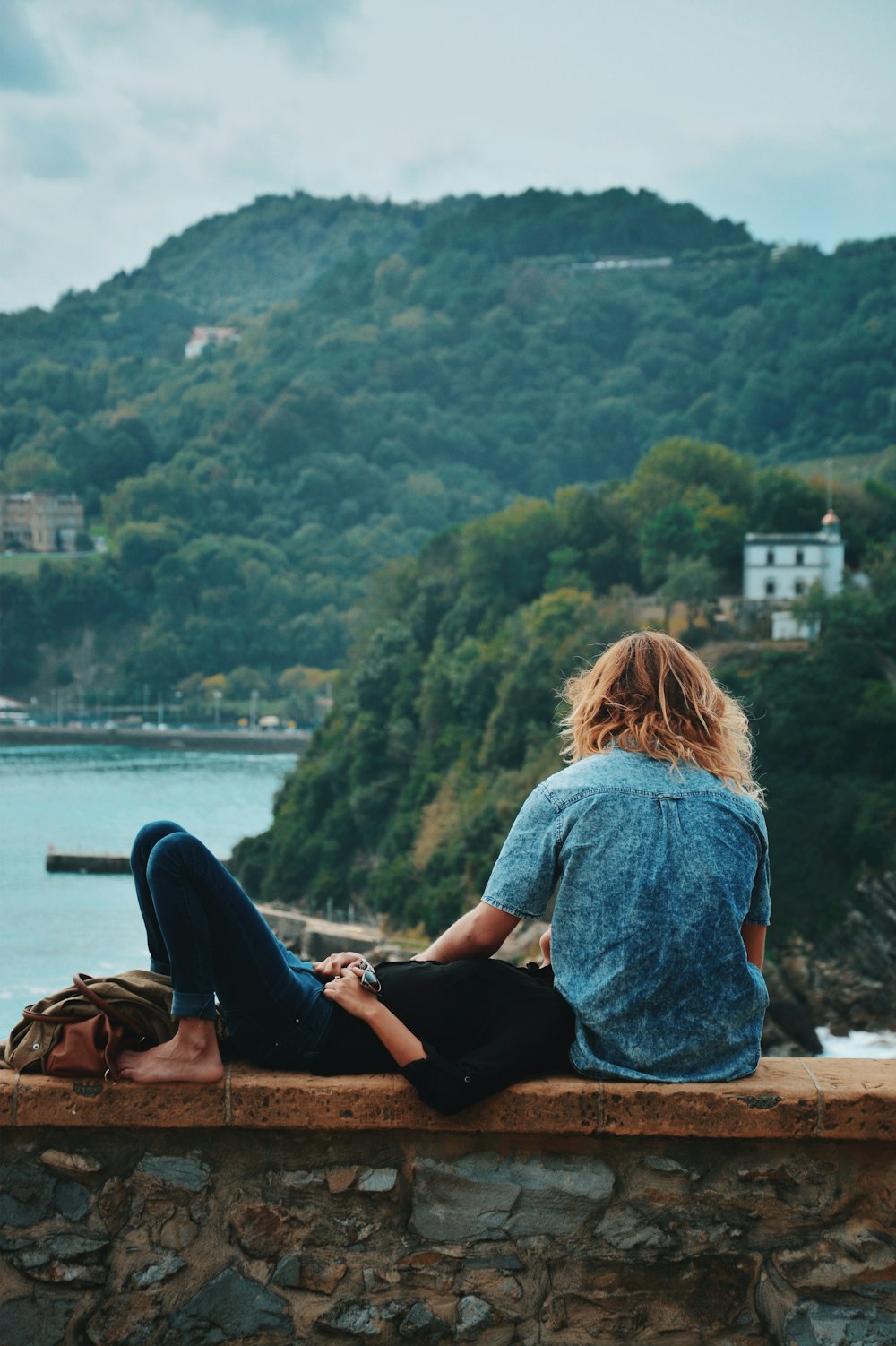 two person sitting on brown concrete bench outdoor during daytime