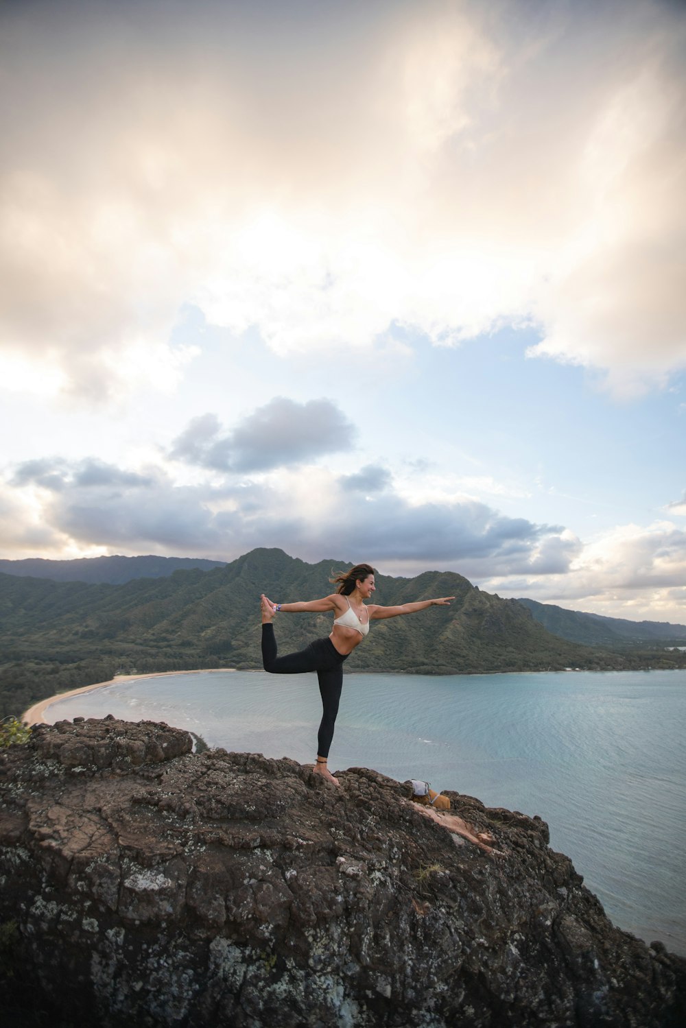 man doing yoga on rock formation