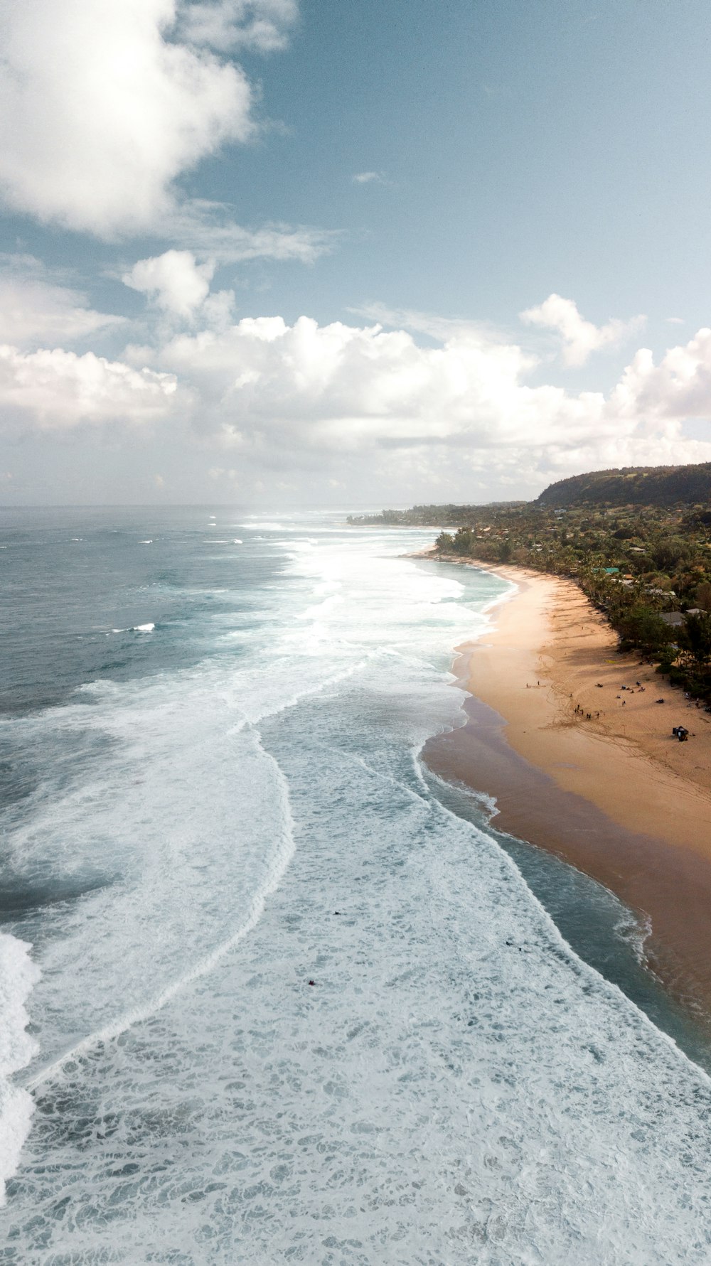 high-angle photography of water crashing on shore during daytime