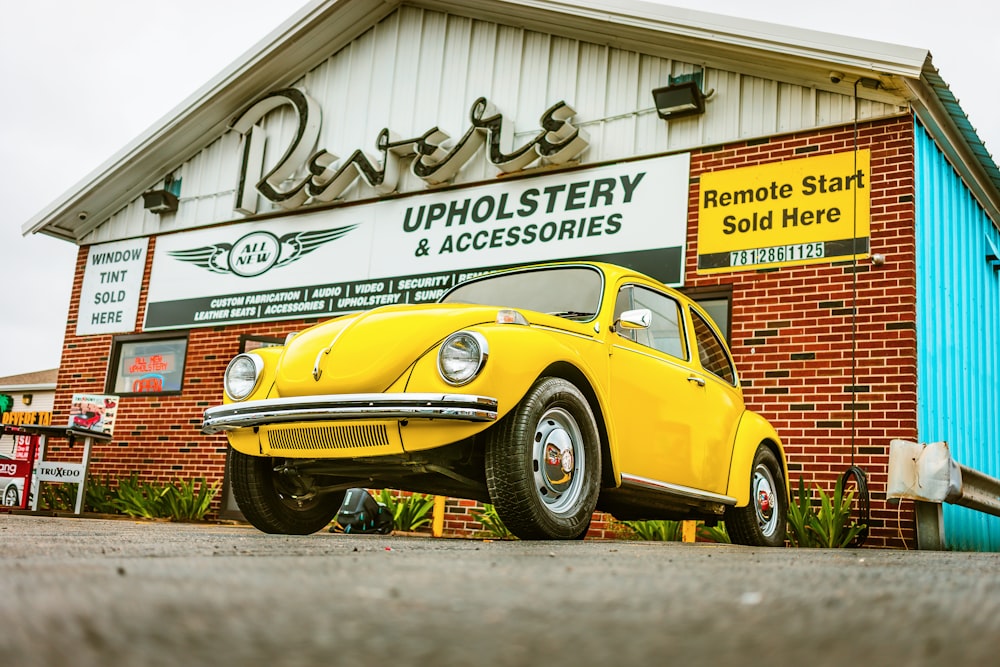 Volkswagen Beetle amarillo estacionado en la tienda de tapicería y accesorios Revere