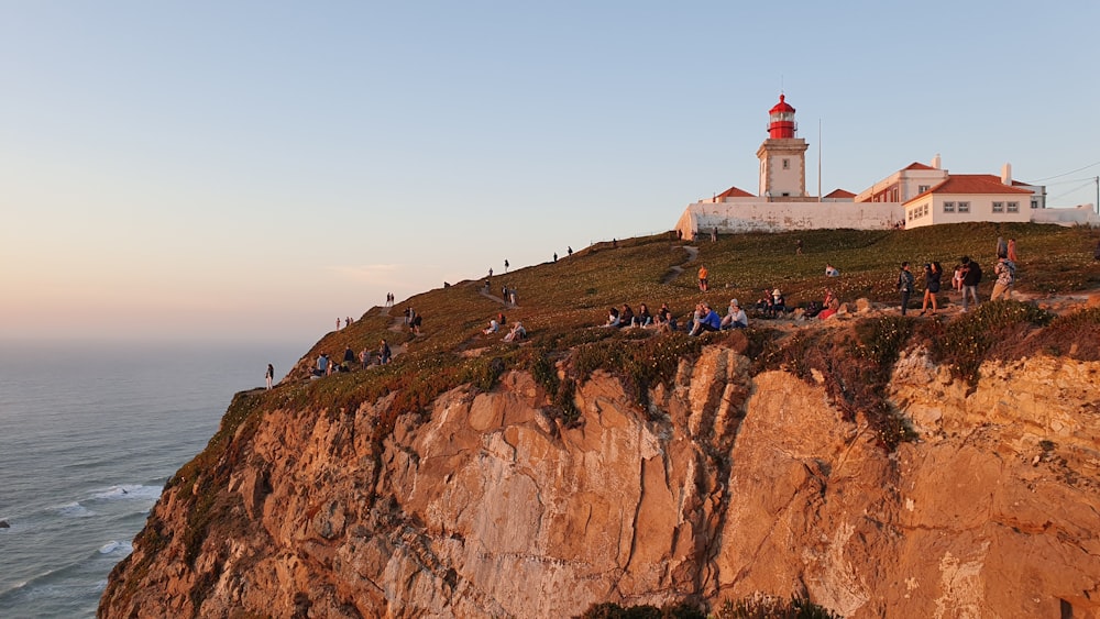 group of people at top of mountain beside sea