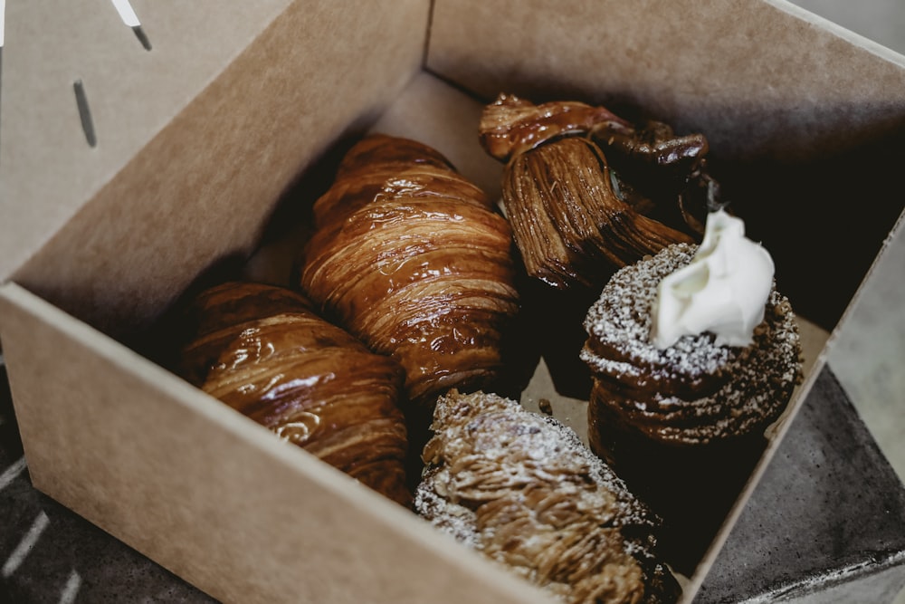 five croissants in brown box