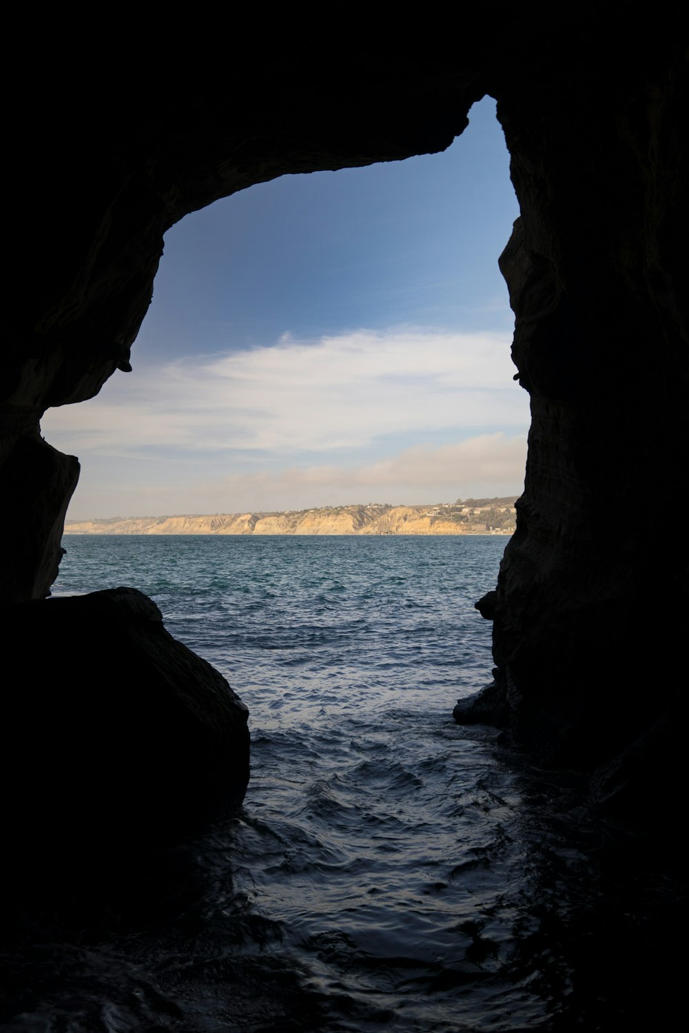uma visão de um corpo de água através de uma caverna