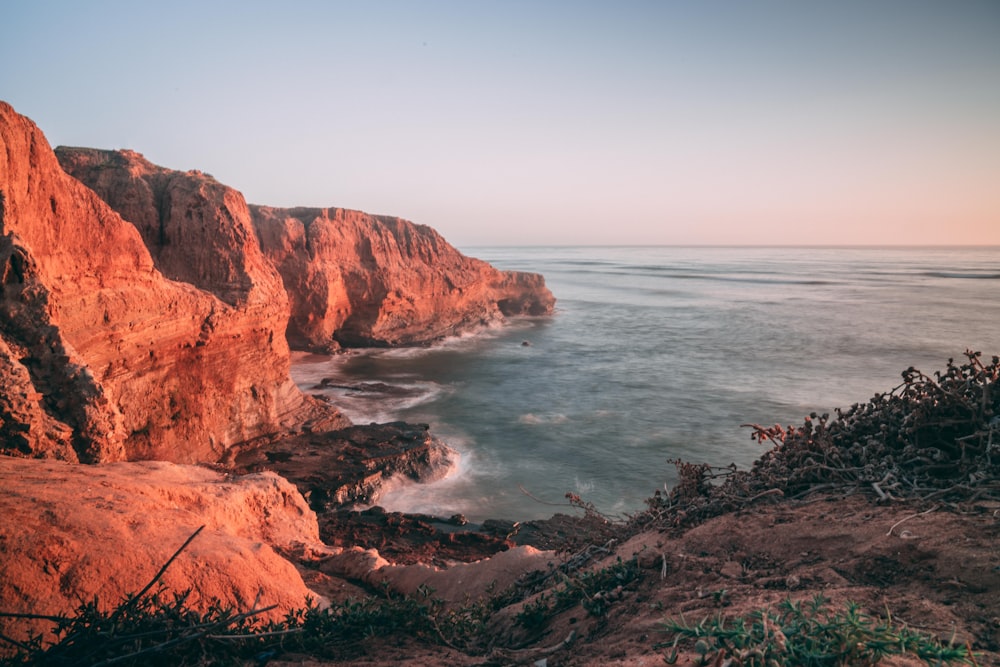 brown cliff under gray sky