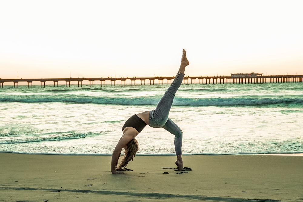 woman doing yoga pose on seashore
