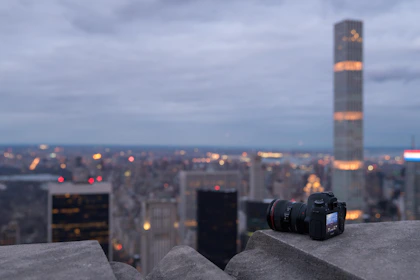Close-up of a sleek camera setup capturing a vibrant cityscape at dusk.