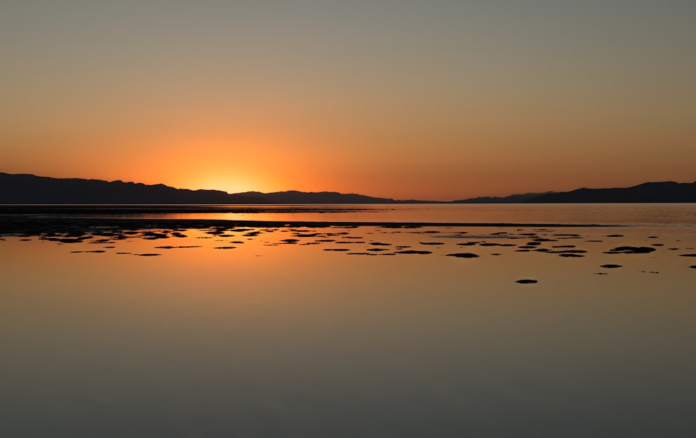 calm body of water viewing mountain during sunrise