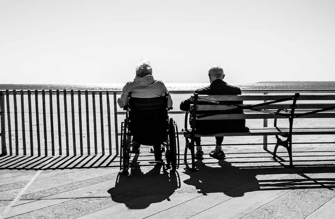 Caregiver looking tired but resilient while sitting with a senior loved one - Support for caregivers Caregiver looking tired but resilient while sitting with a senior loved one - Support for caregivers