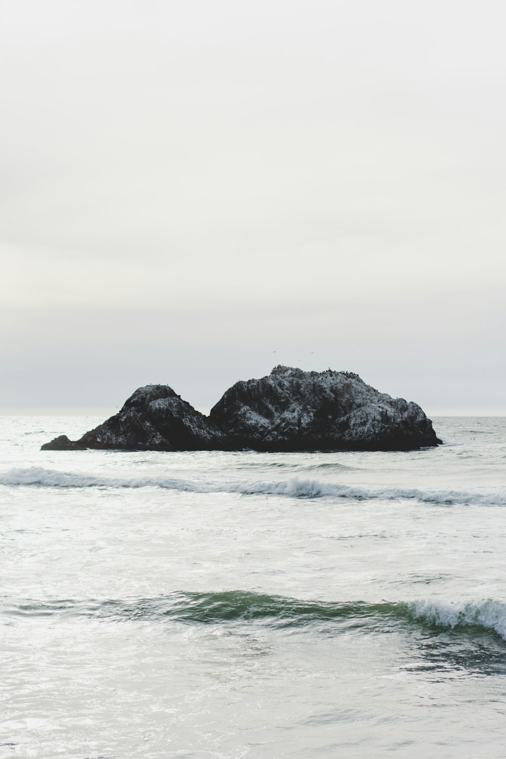 gray rocks on body of water during daytime