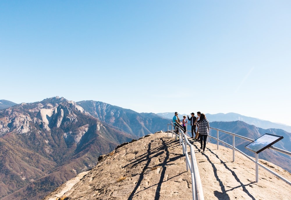 people standing between rails on mountain