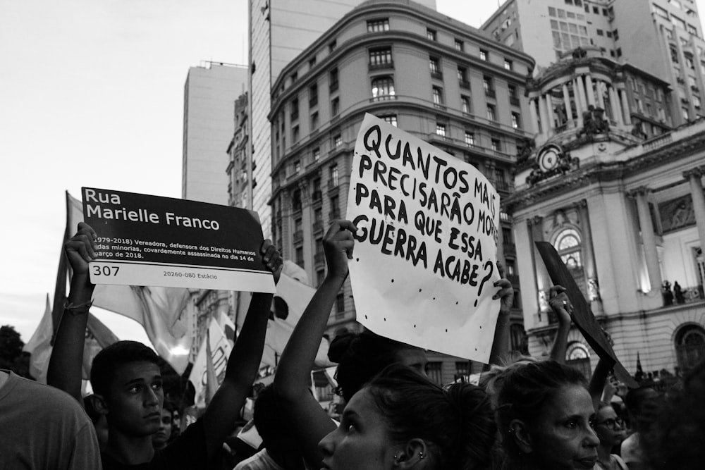 grayscale photography of people raising signages