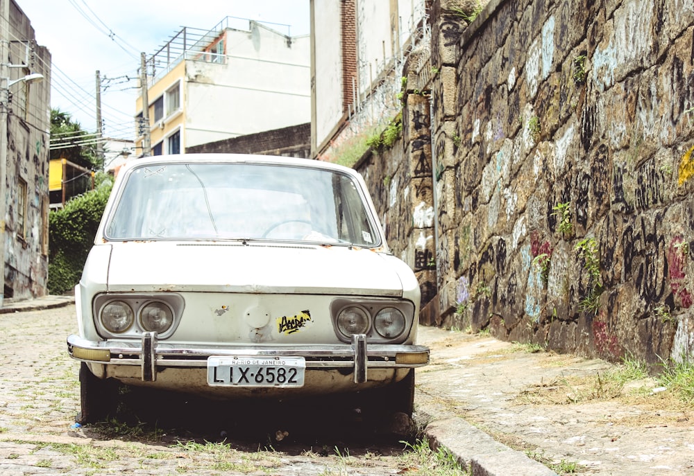 white car beside wall