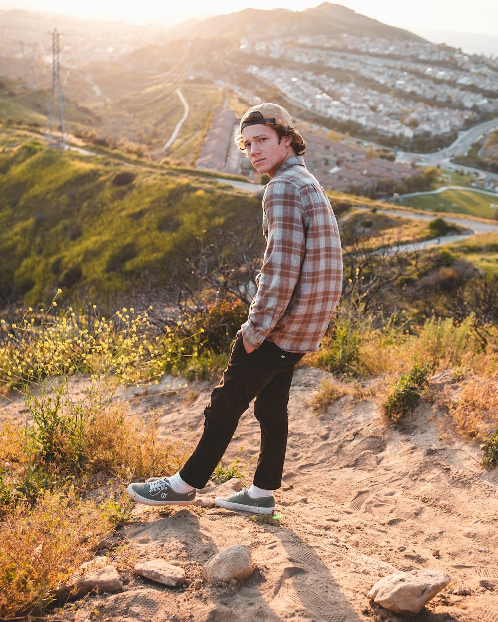 man wearing sport shirt standing on hill