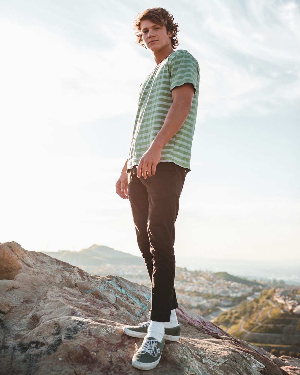 man wearing t-shirt standing on rock