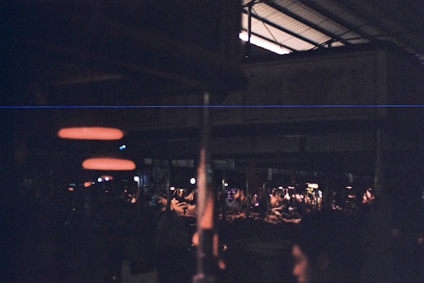 A dimly lit urban marketplace with diverse products displayed on rustic tables.