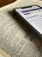 silver iPhone X displaying cannabis definition on top of dictionary