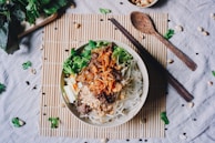 A steaming bowl of international cuisine served with chopsticks.