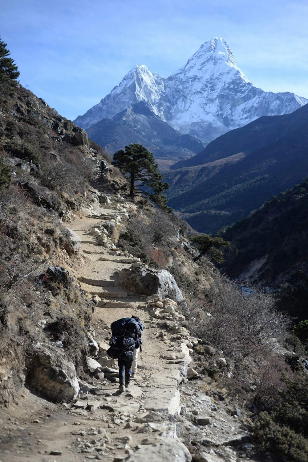 man wearing backpack climbing the mountain