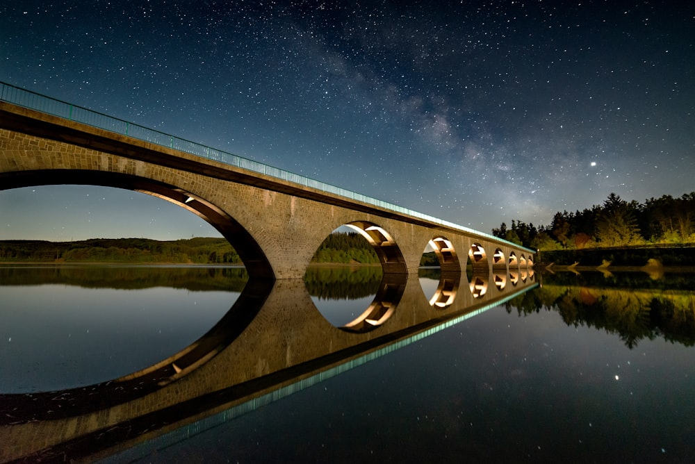 brown concrete bridge over water during night