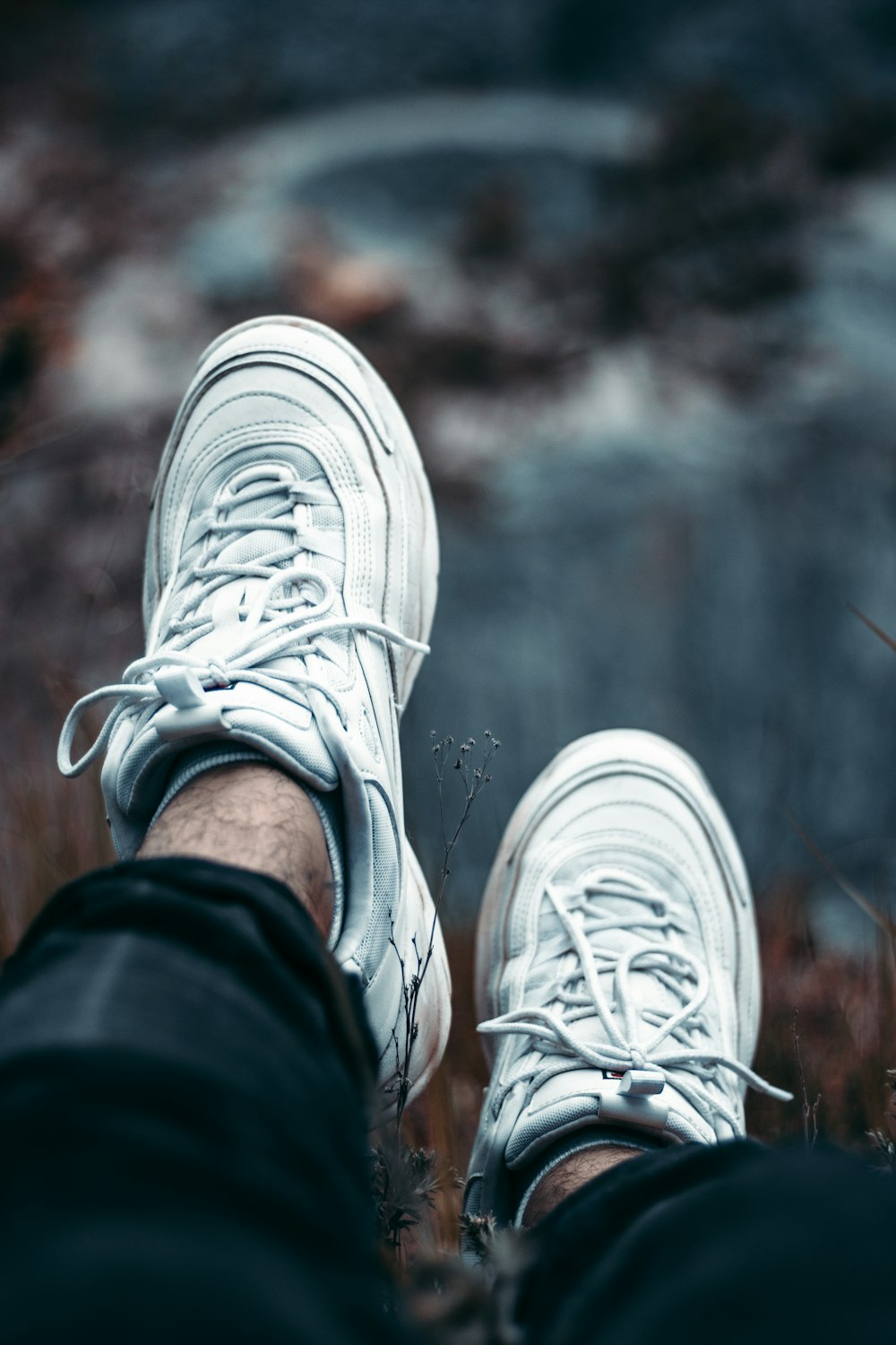 person sitting and wearing white low-top shoes