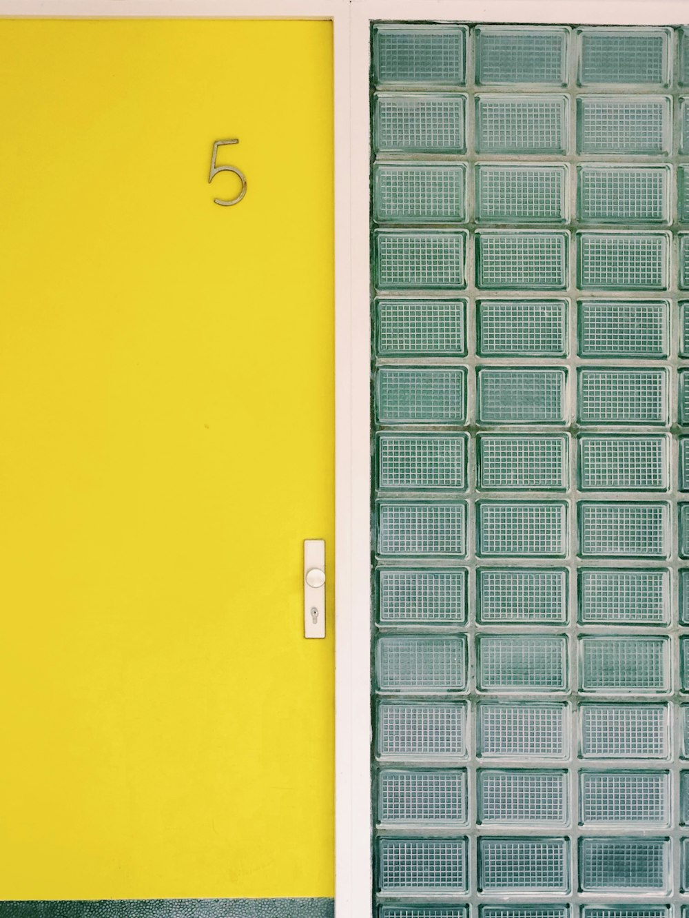 close yellow door by pressurized glass wall