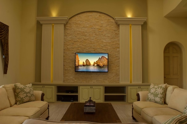 A cozy living room with a smart TV displaying a serene 4K oil painting of a countryside landscape.