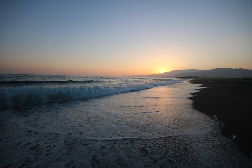 Foto da paisagem de uma praia ao nascer do sol
