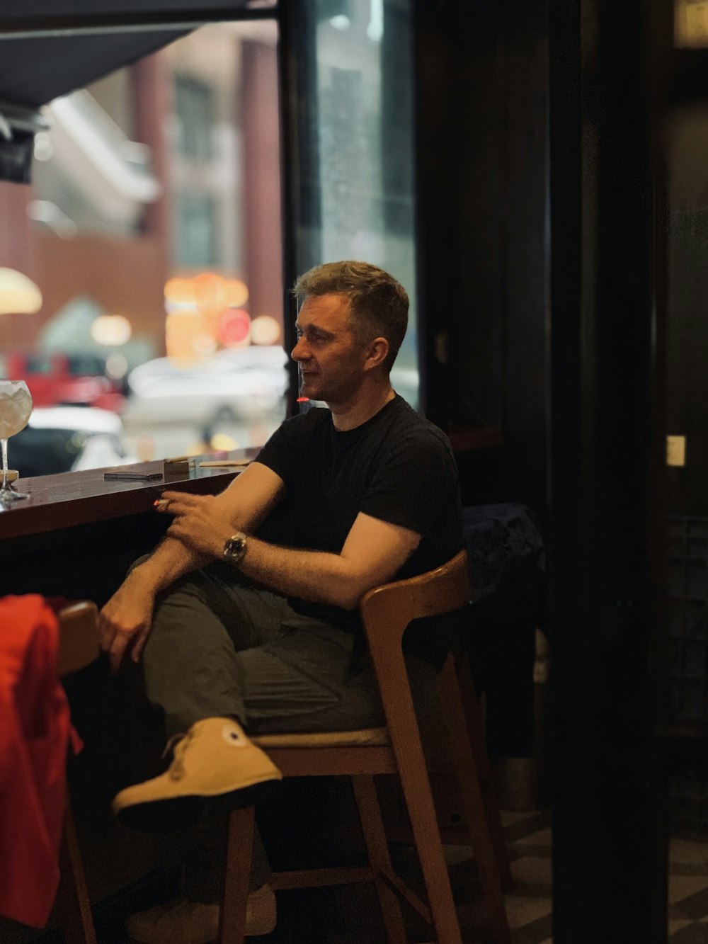 man sitting on bar chair beside counter