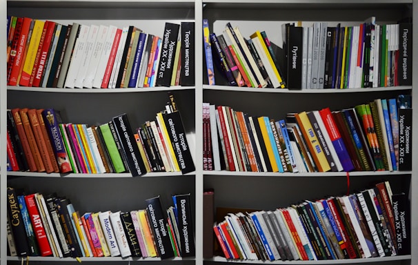 assorted books on a white shelf