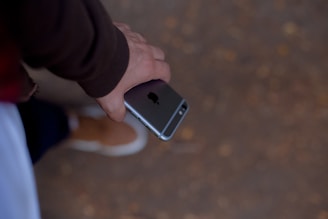 A friendly person browsing a smartphone showing product reviews on a neutral-toned background.