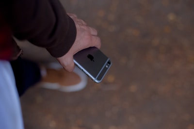 A friendly person browsing a smartphone showing product reviews on a neutral-toned background.