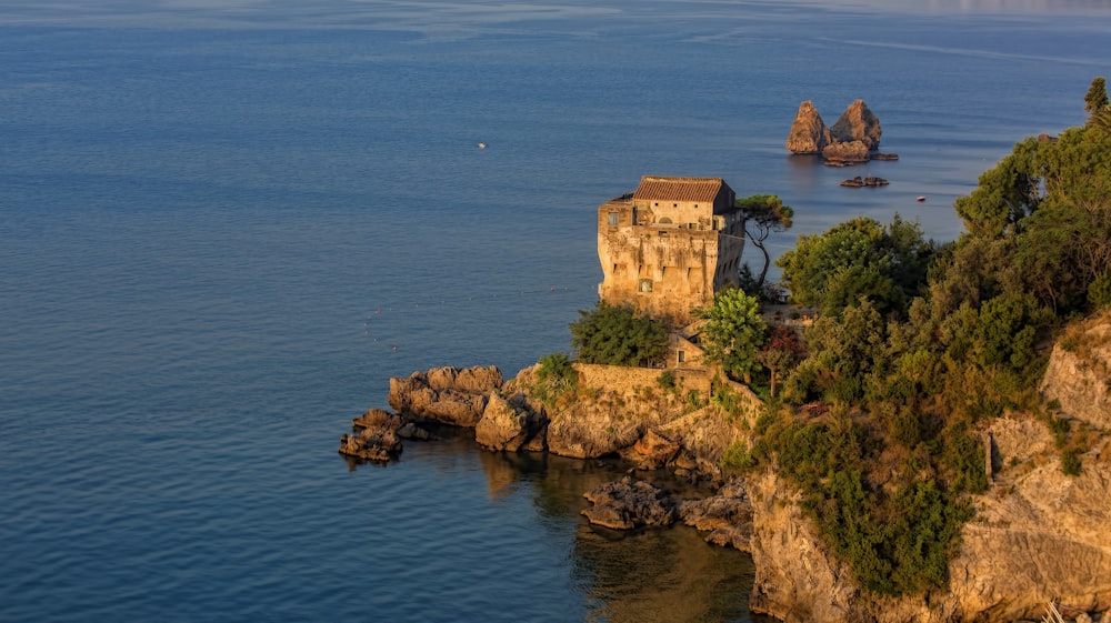 brown building on a cliff by the sea