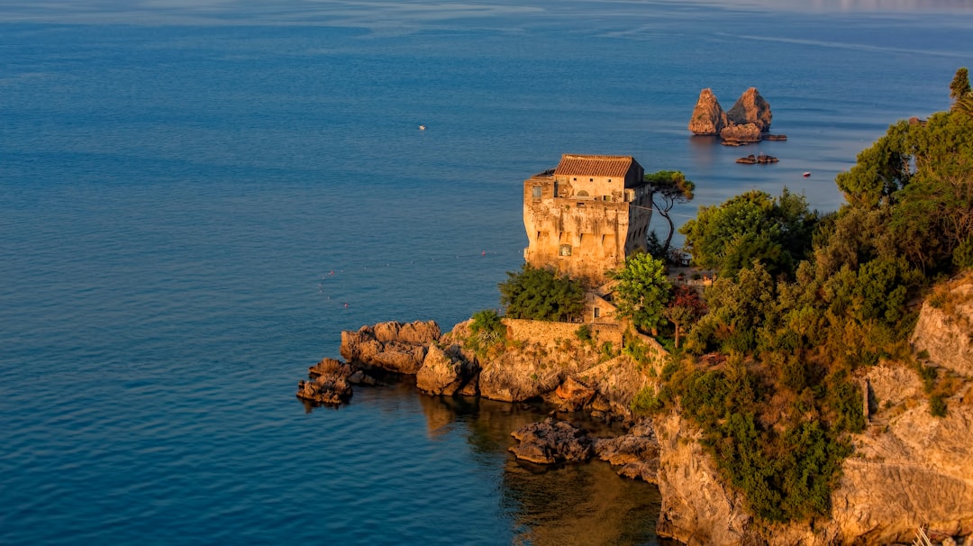 brown building on a cliff by the sea