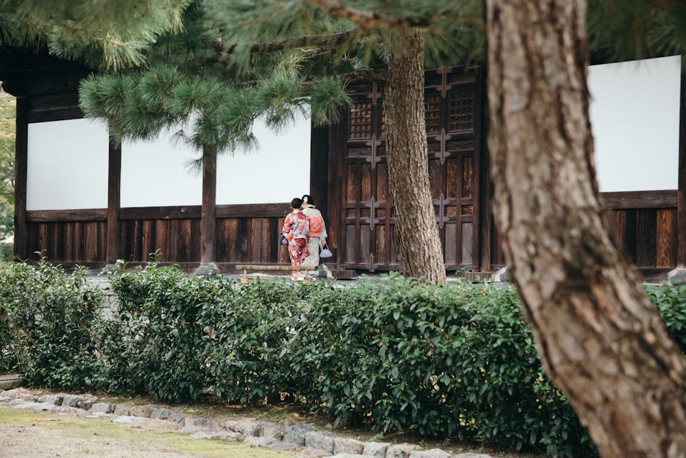 two women in kimono by a white and brown building