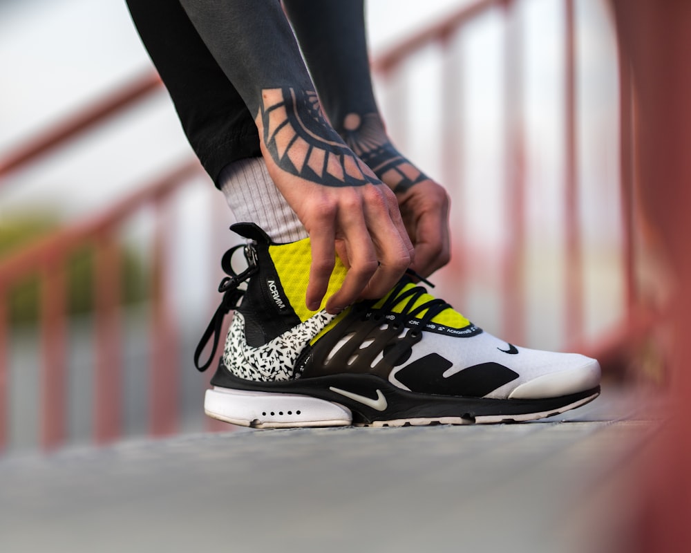 unpaired white, black, and yellow Nike shoe