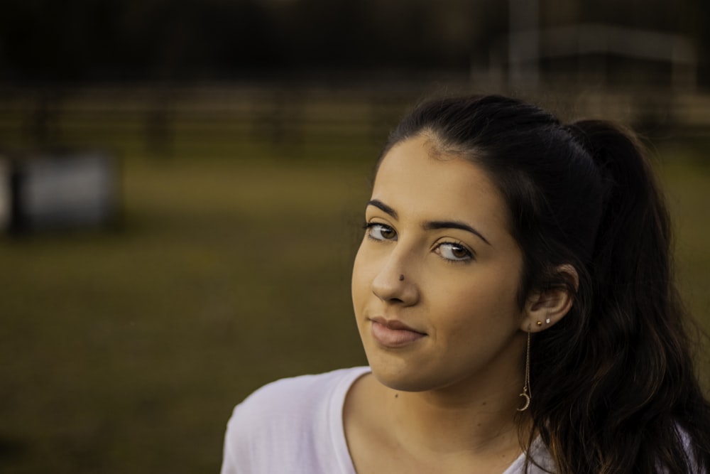 woman wearing drop earring on grass field