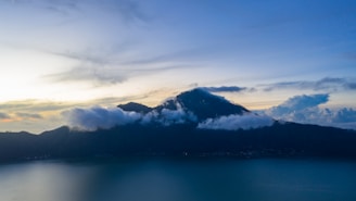 A serene mountain landscape at dawn with soft pastel colors reflecting calm and peace.