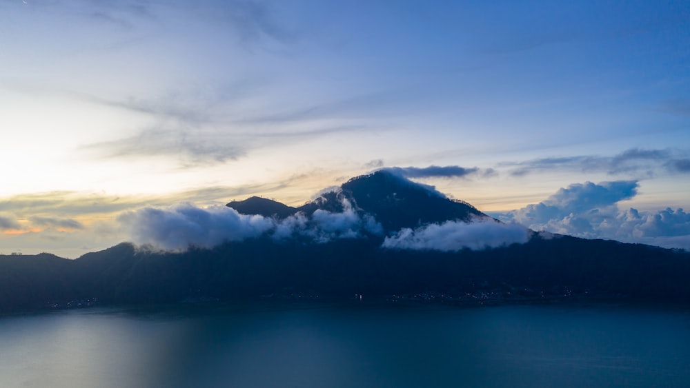 구름으로 둘러싸인 산의 실루엣 사진