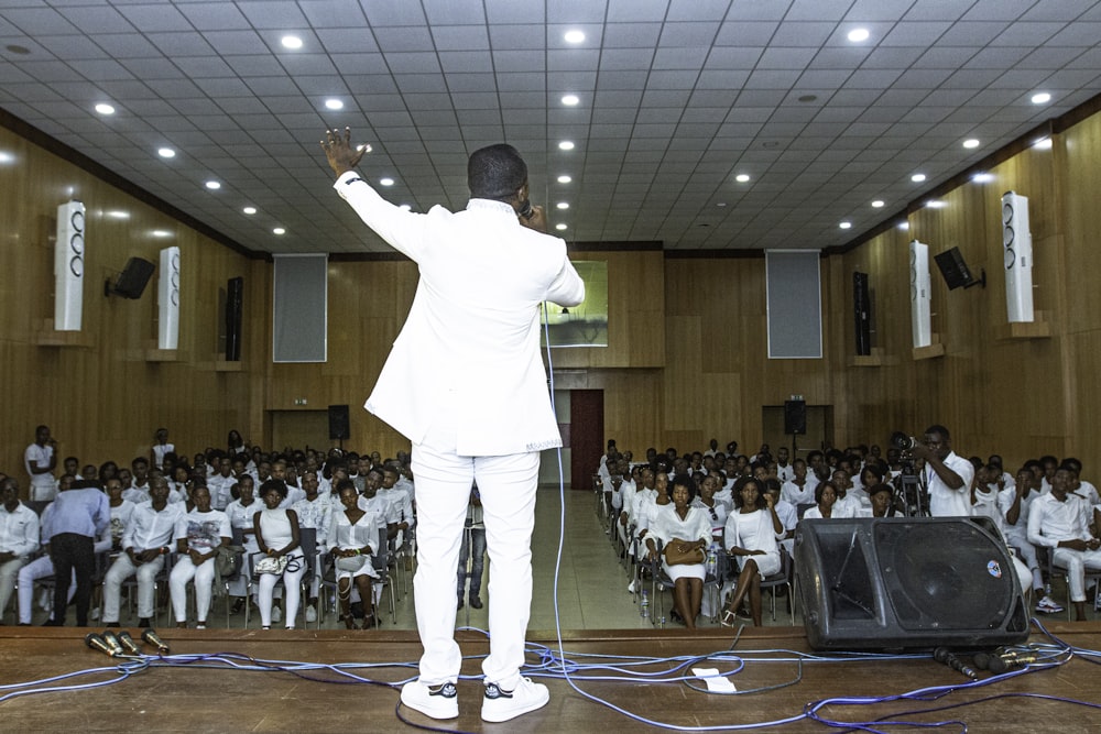 man standing on stage in front of people