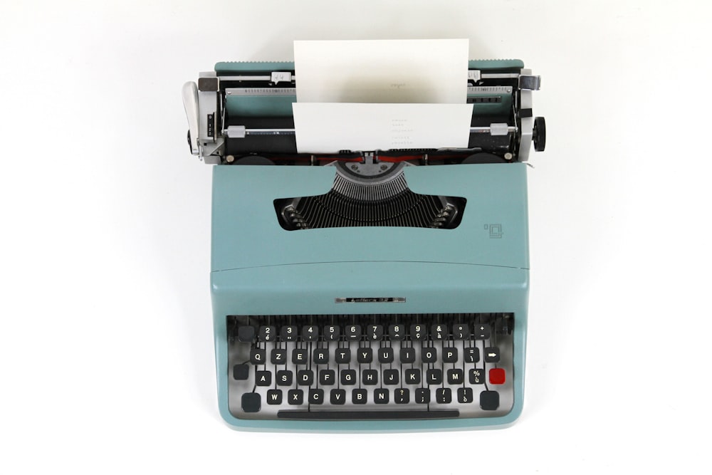 teal and black typewriter machine