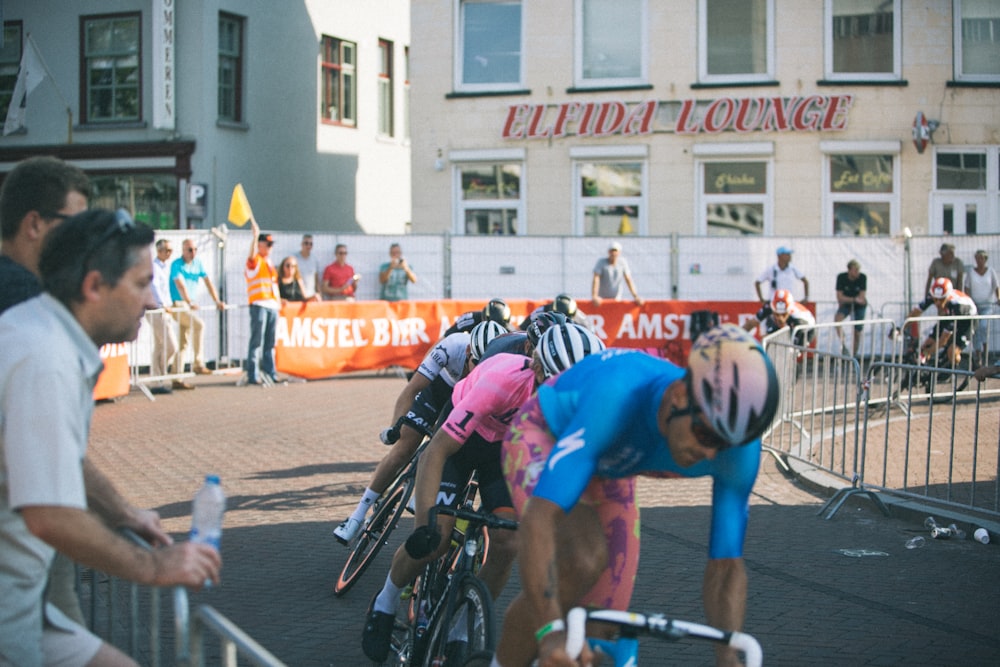 men riding road bikes near handrails and people