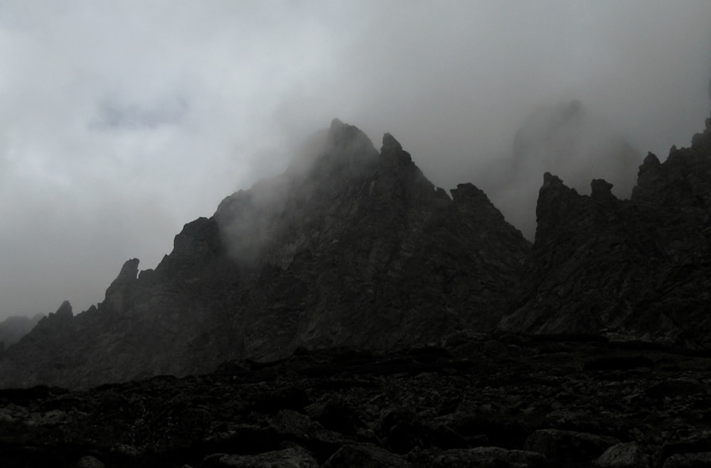 grayscale photo of a foggy mountain