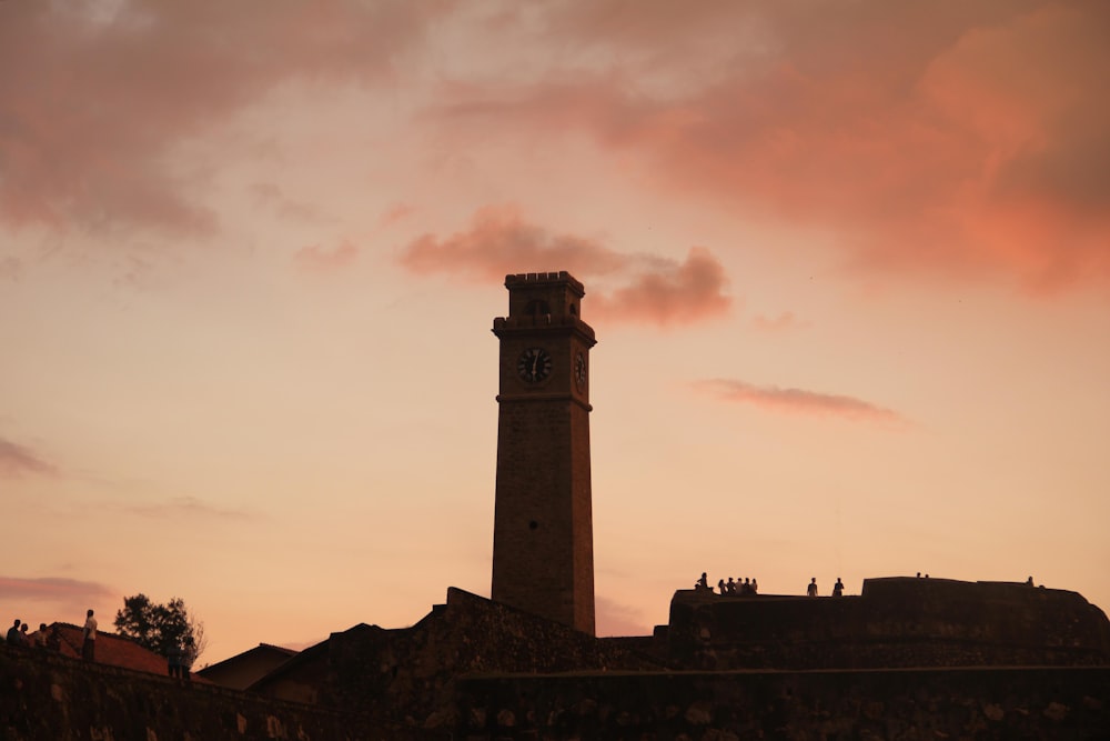 grey and pink cloudy sunset sky over tower